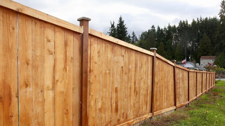 Cap and trim cedar fence with a finished framed top rail