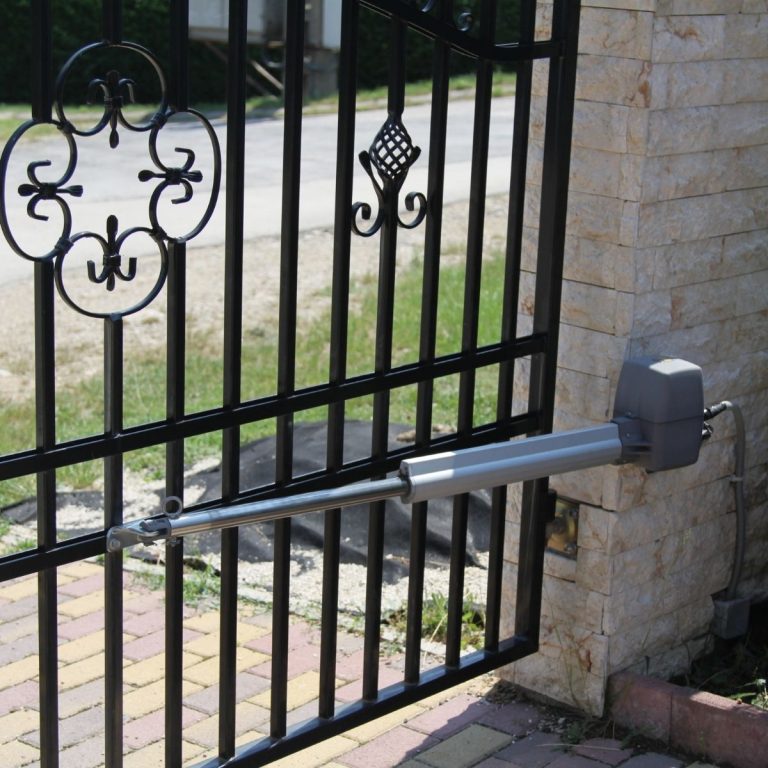 Swing driveway gate with an automatic opener arm mounted on a stone column