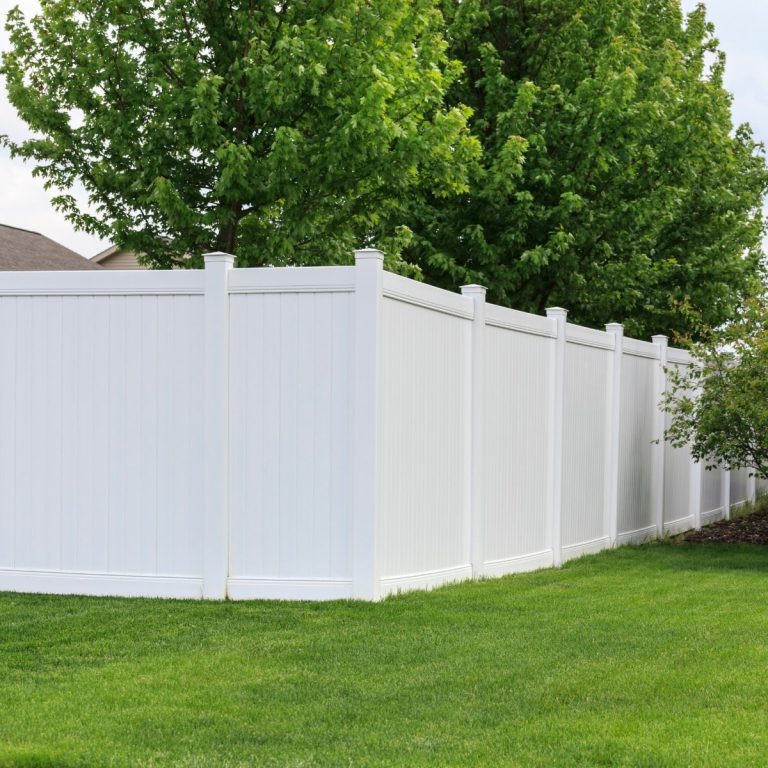 White vinyl privacy fence around a landscaped backyard in Montgomery County
